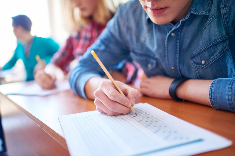 studente al banco di scuola scrive